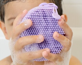 Pebbl silicone bath and shower brush. Dispenses and lathers soap. Helps child gently scrub body and hair. Builds dexterity & motor skills.