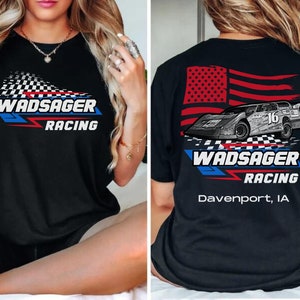 Peut inclure: T-shirt noir avec un drapeau &agrave; damier blanc et le texte "Wadsager Racing" sur le devant. Le dos du t-shirt pr&eacute;sente un drapeau am&eacute;ricain, une voiture de course et le texte "Wadsager Racing Davenport, IA".