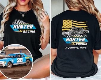 Puede incluir: Una camiseta negra con un gráfico de un coche de carreras con el número 28, una bandera estadounidense amarilla y el texto Hunter Racing Wyoming, Iowa. El frente muestra el logo de Hunter Racing y la espalda el diseño completo del coche.