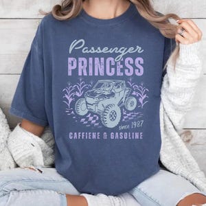May include: A navy blue t-shirt with a graphic of a side-by-side vehicle and the text "Passenger Princess since 1987 Caffeine & Gasoline".