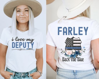 May include: White t-shirt with the text "i love my DEPUTY" on the front and the text "FARLEY Back The Blue" with a blue and white police badge and floral design on the back.