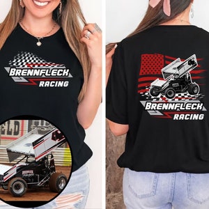 Peut inclure: T-shirt noir avec un motif de drapeau &agrave; damier blanc et rouge et le texte "Brennflec Racing" sur le devant. Le dos du t-shirt pr&eacute;sente une illustration en noir et blanc d'une voiture de course avec un drapeau am&eacute;ricain et le texte "Brennflec Racing".