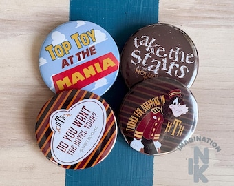 Peut inclure: Quatre badges ronds avec des motifs variés. L'un est bleu clair avec des nuages et le texte Top Toy at the Mania. Un autre est marron avec le texte blanc take the stairs at the Hollywood Tower. Deux autres présentent des rayures avec le texte Do You Want The Hotel Tour? et Thanks for Dropping In accompagné d'une illustration de personnage.