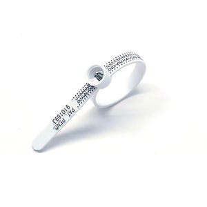 Op de afbeelding: Een witte plastic ringenmaat met een zwarte geprinte schaal en de tekst "PAT PEND 6101693".