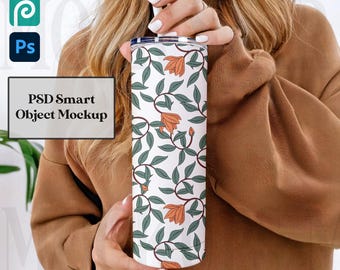 May include: A white tumbler with a floral design featuring orange flowers and green leaves. The tumbler has a straw and a lid. The text "PSD Smart Object Mockup" is visible in the image.