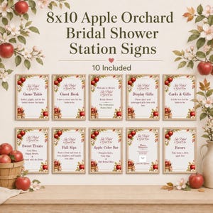 May include: A set of ten 8x10 inch bridal shower station signs featuring an apple orchard theme with red apples and white blossoms. Each sign includes text such as Game Table, Guest Book, and Apple Cider Bar, framed in a light wood border.