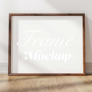 May include: A brown wooden frame with a white background. The text "Frame Mockup" is written in white on the background.