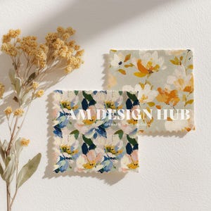 May include: Two fabric swatches with floral patterns in shades of yellow, blue, and white. The swatches are square with frayed edges. Dried yellow flowers are arranged on the left side. The text "AM DESIGN HUB" is printed on one of the swatches.