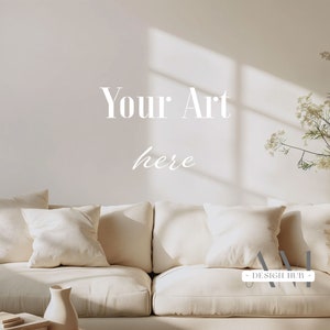 Peut inclure: Un canapé blanc avec des coussins dans un salon. Le mur est blanc avec le texte "Your Art here" écrit dessus. Il y a une plante dans le coin de la pièce.