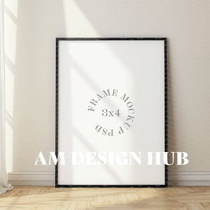 May include: A black picture frame mockup with a white background. The frame is sitting on a wooden floor with a white wall behind it. The text "FRAME MOCKUP 3x4 PSD" is visible in the frame.
