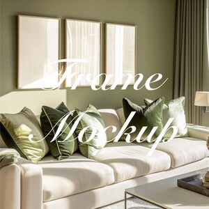 May include: A white sofa with green throw pillows in a living room with three framed pictures on the wall. The sofa is in front of a window with green curtains.