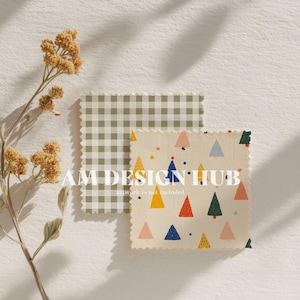 May include: Two fabric swatches with decorative edges. One is a green and white gingham pattern. The other is a cream-colored fabric with colorful triangle tree designs. A dried flower stem is in the upper left corner. The text "AM DESIGN HUB" is visible.