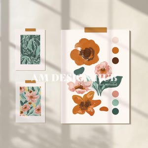 Könnte beinhalten: Drei gerahmte Kunstdrucke mit floralen und botanischen Designs, die mit Klebeband an der Wand befestigt sind. Die Kunstwerke zeigen orange, rosa und grüne Blumen, mit einer Farbpalette auf der rechten Seite. Der Text "AM DESIGN HUB" ist sichtbar.