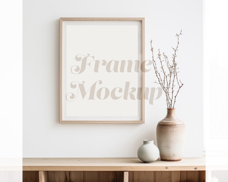 May include: A wooden frame mockup with a white background, a vase with dried branches and white flowers, and a smaller vase on a wooden shelf.