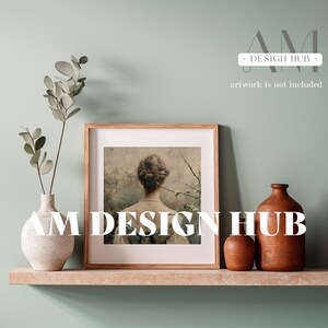 May include: A wooden frame with a picture of a woman with her back to the camera. The picture is on a shelf with two brown ceramic vases and a green plant.