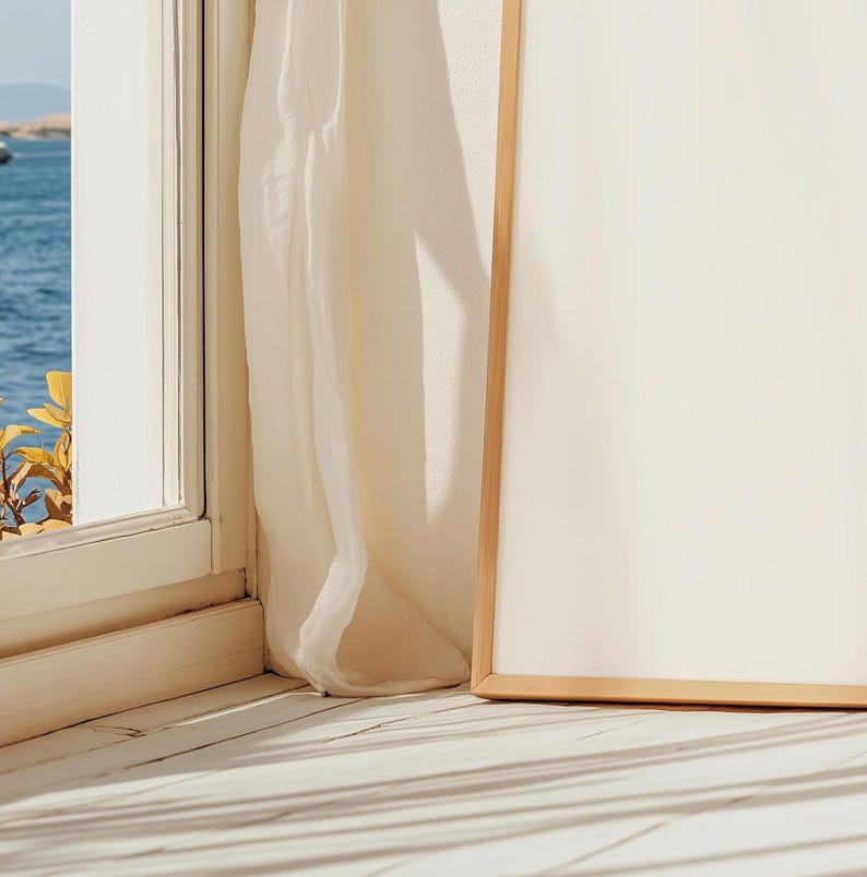 May include: A white canvas with a wooden frame sits on a white wooden floor. The canvas is blank and ready for a painting or artwork. The floor has natural light shining through a window, creating shadows.