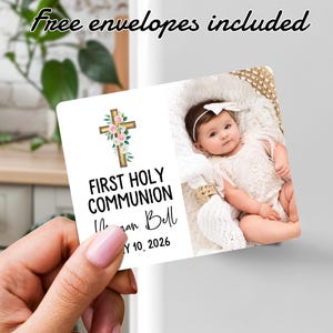 Pode incluir: Um cartão de Primeira Comunhão com uma foto de bebê, uma cruz floral e o texto "Primeira Comunhão" com um nome e uma data. O cartão inclui o texto "Envelopes grátis incluídos" em uma fonte de escrita.