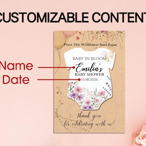 May include: A customizable baby shower invitation card with the text "BABY IN BLOOM" and "Emilia's BABY SHOWER 11.08.2026". The card features a onesie design with floral accents and the words "Plant This Wildflower Seed Paper".