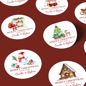 May include: A collection of round Christmas stickers with watercolor illustrations. Designs include Santa Claus, a Christmas tree with a deer, a snowman, and a cozy cabin. Each sticker has the text "MERRY CHRISTMAS Love from Candie & Dylan."