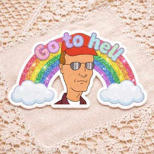 May include: A sticker featuring a cartoon character wearing a red cap and sunglasses, set against a rainbow and clouds. The text "Go to hell" is written across the top in colorful, glittery letters.