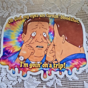 May include: A sticker featuring a cartoon illustration with the text "Oh God, my eyes are turnin' bloodshot. I'm goin' on a trip!". The design includes a tie-dye background and a character with bloodshot eyes.