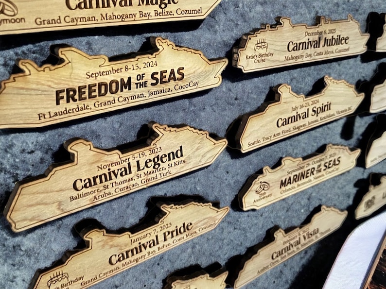 May include: A collection of wooden cruise ship souvenirs featuring the names of different ships and their itineraries. The ships are all in the same style, with a simple outline of a cruise ship and the name of the ship and its itinerary printed below.