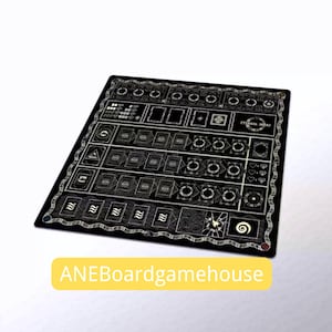 Puede incluir: Tapete negro para juegos de mesa con intrincados diseños plateados y el texto "ETERNAL DECKS". El tapete presenta varias formas y símbolos, incluyendo cuadrados, círculos y corazones. El texto "ANEBoardgamehouse" se muestra en un rectángulo amarillo.