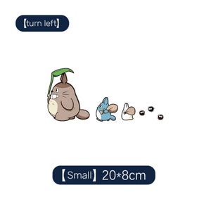 May include: A cartoon illustration of Totoro and other characters from the movie My Neighbor Totoro. The illustration is in a line, with Totoro holding an umbrella in the front, followed by a blue cat-like creature, a white rabbit-like creature, and several small, black, round creatures. The text "[turn left]" is in a box above the illustration, and the text "[Small] 20*8cm" is in a box below the illustration.