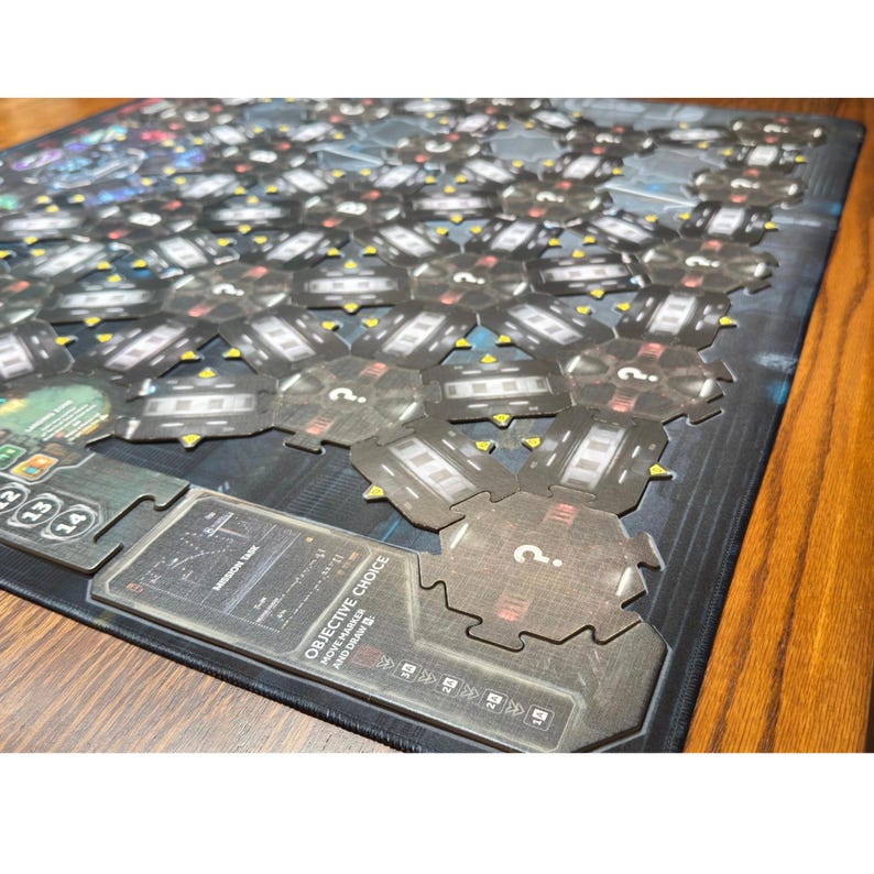 May include: A board game with a dark blue and grey colour scheme. The game board is covered with hexagonal tiles and includes informational cards with text. The game appears to be a strategy or adventure game.