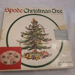 May include: A vintage Spode Christmas Tree box. The box features a detailed illustration of a decorated Christmas tree with gifts at the base. The words "Spode Christmas Tree" are at the top. A smaller image of a serving tray is on the lower left.