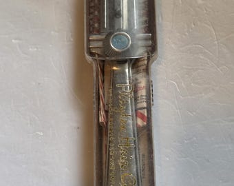 May include: Vintage hair cutter in a clear plastic case. The metal handle is engraved with "Playboy Hair Cutter" in gold lettering. The cutter has a clear plastic top with a blue button.
