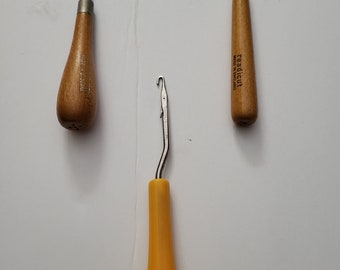 May include: Three crochet hooks with wooden and plastic handles. The hooks are different sizes and colors. The wooden hooks have the text "Made in England" and "readicut" printed on them.