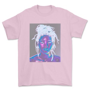 May include: A pink t-shirt with a graphic of a woman with white hair and a purple and blue face.