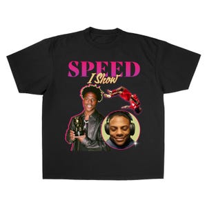 以下が含まれることがあります： ピンクと黄色の「SPEED I Show」の文字が入ったグラフィックが特徴の黒いTシャツ。デザインには、トロフィーを持っている人、ヘッドフォンを着用している人、空中にいる人の画像が含まれています。