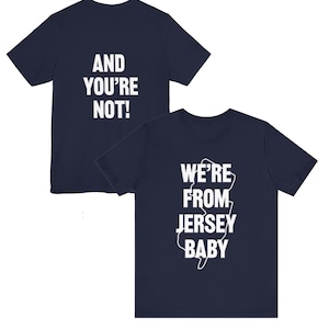 May include: Two navy blue t-shirts. One shirt has the text "AND YOU'RE NOT!" in white. The other shirt has the text "WE'RE FROM JERSEY BABY" with a white outline of the state of New Jersey.