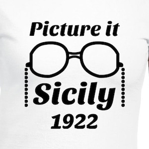 May include: White t-shirt with black text that reads "Picture it Sicily 1922" and a pair of round glasses with a chain.