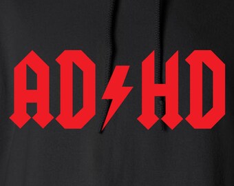 Pode incluir: Moletom preto com o texto vermelho "AD⚡HD". O texto está em uma fonte ousada e estilizada com um raio substituindo a letra "C". O moletom tem um bolso frontal e um capuz com cordão.