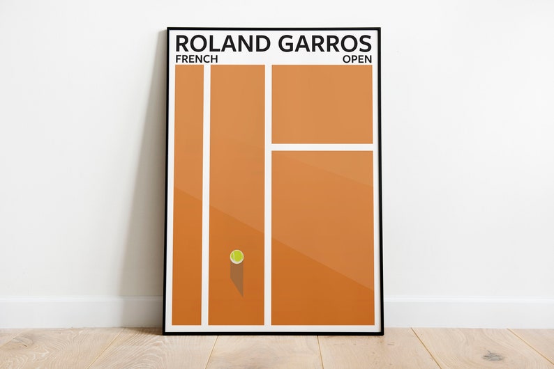 K&ouml;nnte beinhalten: Ein minimalistisches Poster mit schwarzem Rahmen, das einen Sandtennisplatz mit einem einzigen Tennisball in der Mitte zeigt. Der Text "Roland Garros" befindet sich oben auf dem Poster, mit "French" links und "Open" rechts.