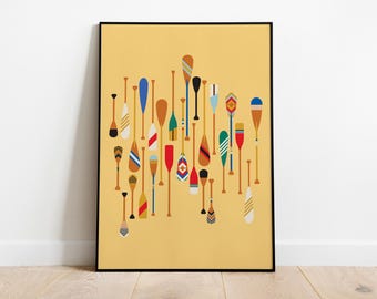 May include: A framed vertical wall art print featuring a collection of various canoe paddles arranged in a cluster against a solid mustard yellow background. The paddles display diverse patterns, shapes, and colours including blue, red, green, and white.
