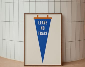 May include: A framed wall art print featuring a blue triangular pennant shape on a cream background. The text LEAVE NO TRACE is printed in white capital letters inside the pennant. The pennant has a brown horizontal bar at the top with two tabs.