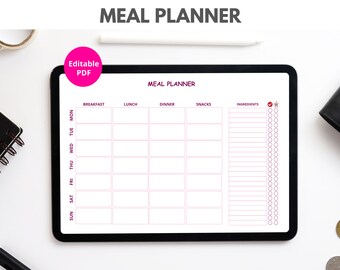 May include: A digital tablet displaying a meal planner with sections for breakfast, lunch, dinner, snacks, and ingredients. The planner is on a white surface with a black pen and a roll of tape.
