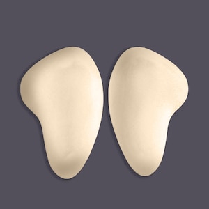 May include: Two beige foam pads shaped like a teardrop, designed to add volume to the hips.