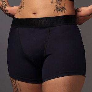 May include: Navy blue boxer briefs with a black waistband. The waistband features the text "ITA". The briefs are made of a soft, opaque fabric. The image shows the briefs from the waist down.