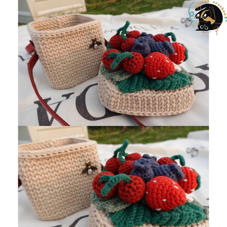 May include: A crocheted basket with a red strap and a crocheted fruit basket with strawberries, blueberries, and cherries. The fruit basket is beige with green leaves.