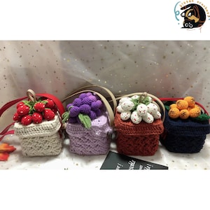 May include: Four crocheted mini bags with different fruit designs. The bags are white, purple, orange, and blue. Each bag has a crocheted strap.