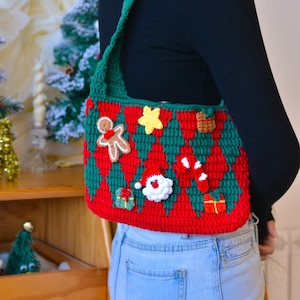 May include: A red and green crocheted shoulder bag with a Christmas theme. The bag features various festive embellishments, including a gingerbread man, a candy cane, a star, and a Santa Claus.