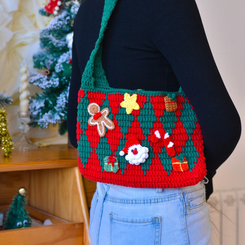 May include: A red and green crocheted shoulder bag with a Christmas theme. The bag features a gingerbread man, a candy cane, a star, a Santa Claus, and a gift.