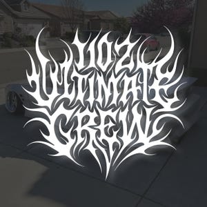 Può includere: Testo bianco stilizzato che recita "Ultimate Crew" in un font a forma di fiamma. Il testo è sovrapposto a un'auto grigia parcheggiata su un vialetto di cemento. Lo sfondo include case e una strada.