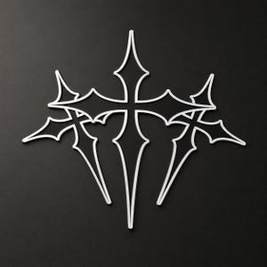 Könnte beinhalten: Ein weißes, stilisiertes Kreuzdesign mit spitzen Enden und einem symmetrischen Layout. Das Design ist vor einem schwarzen Hintergrund platziert und erzeugt einen starken Kontrast. Das Kreuz hat eine gotische oder mittelalterliche Ästhetik.