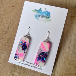 Rectangular Glitter Dangle Earrings. Purple, blue, pink and white glitter resin earrings with silver plated hooks. Approx 5.5cm